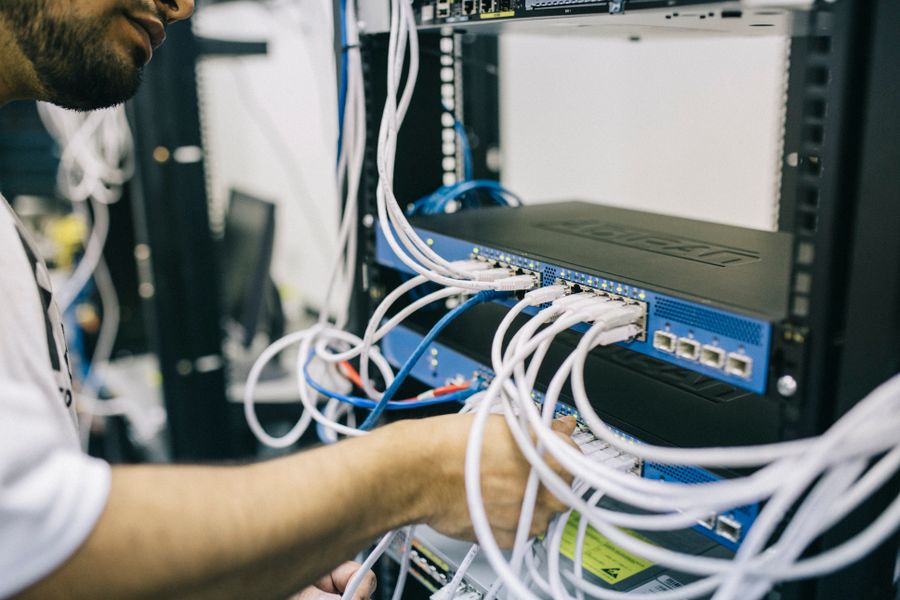An engineer patching network cables into a switch